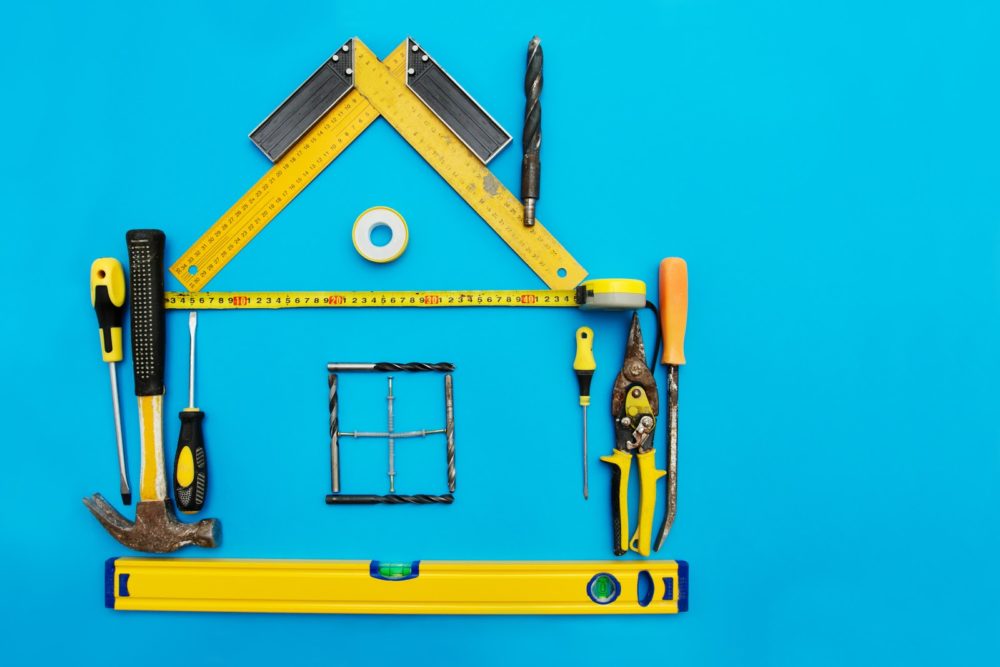 Tools in the shape of house over blue background. Home improvement concept.